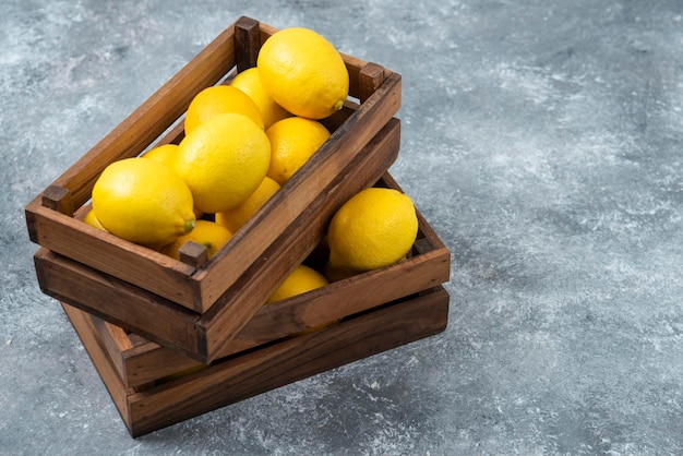 Lemons in wood box on grey backround