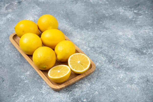 Lemons in wood box on grey backround