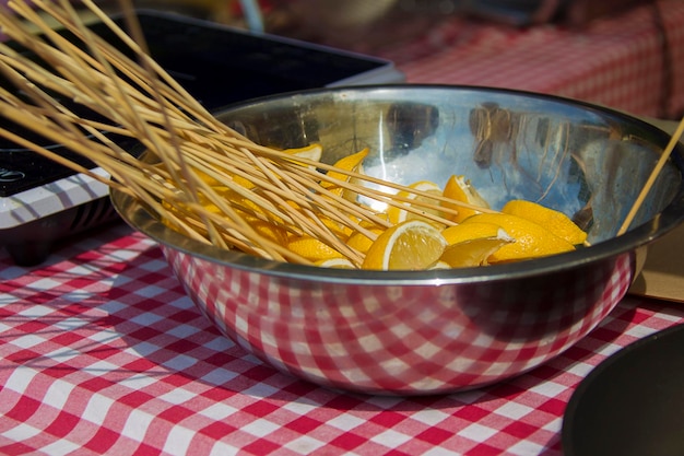 Lemons on a wooden stick in a metal bowl