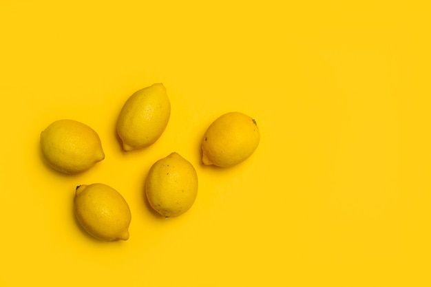 Lemons on a yellow background in a top view