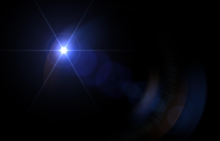 Photo lens flare glow light effect on black image of rays blue light effects overlays or flare isolated on black background for design abstract lens flare light over black background