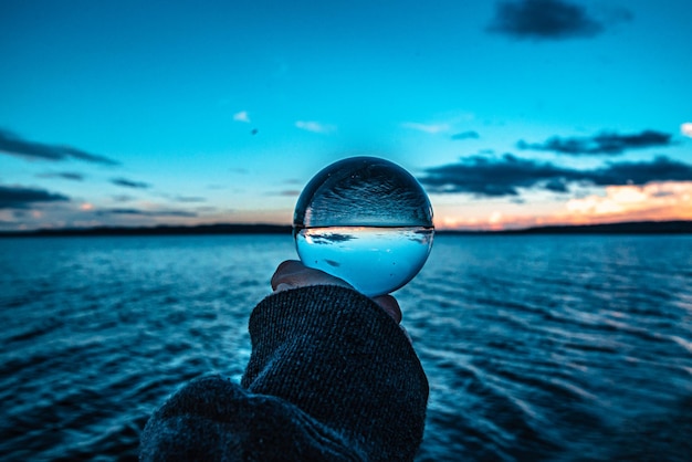 Foto lensball nell'ora d'oro sull'acqua contro il cielo