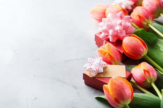 Lente achtergrond met oranje kleurrijke tulpen en geschenkdoos, vrouwen, moederdag, wenskaart, kopie ruimte afbeelding