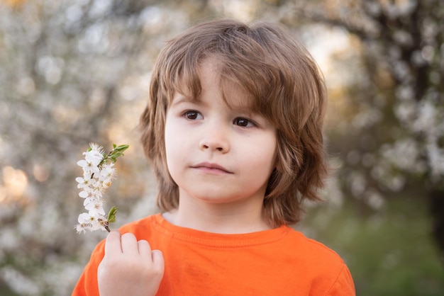 Lente jongen kind kind in bloeiend park gelukkige jeugd en kind aanpassing