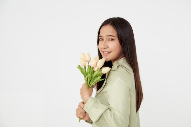 Lente Mooi vrolijk meisje glimlachend en met een boeket tulpenbloemen. Jonge gelukkige Aziatische vrouw.