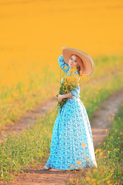 lente natuur jong meisje in een veld van bloemen, vrijheid en geluk van een dame in een zonnig landschap