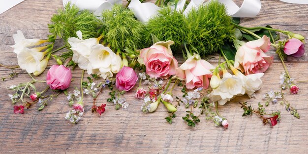 Lente of zomer compositie gemaakt van prachtige bloemen, kruiden en bessen op houten achtergrond floristi
