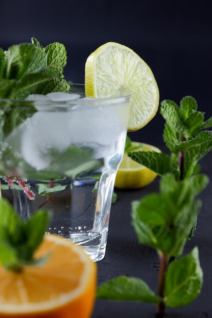 Lente of zomer verfrissende koude cocktail Glas cocktail met munt en citrusvruchten op een zwarte achtergrond Close-up