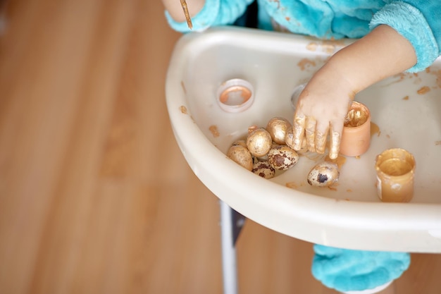 Lente Pasen ansichtkaart concept Baby schildert gouden kwarteleitjes