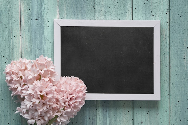 Lente plat lag met roze hyacint bloemen en schoolbord met tekst 