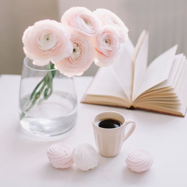 Lente romantisch stilleven met bloemen, koffiekopje, een boek en marshmallows