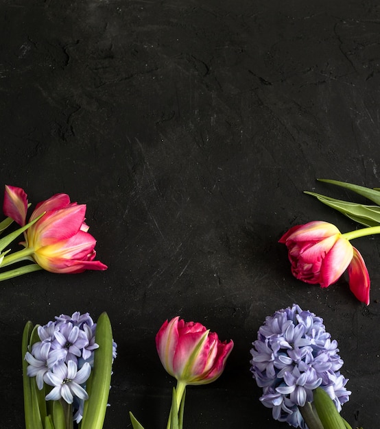 Foto lente roze tulpen en paarse hyacint op bord