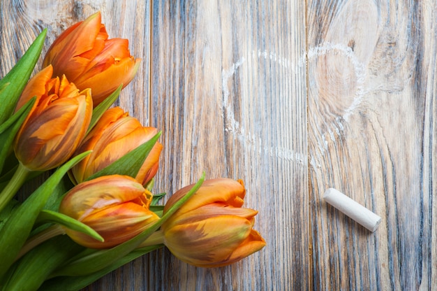 Lente samenstelling met oranje tulpen, krijt en hart tekening