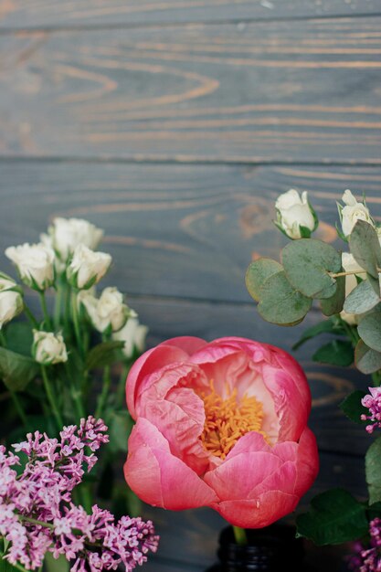 Lente stijlvolle boeket samenstelling op rustiek hout stilleven peony lila eucalyptus rozen