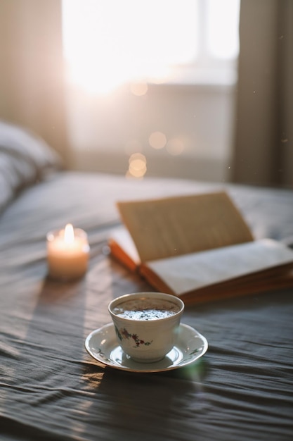 Lente stilleven. Ontbijt op bed. Witte slaapkamer. Zoet huis. Boek en koffiekopje