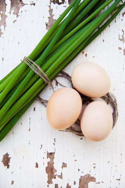 Lente-uitjes en eieren liggen op een oude witte tafel