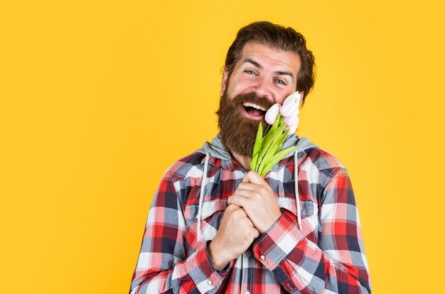 Lente vakantie aanwezig happy Valentijnsdag volwassen man in geruit hemd met tulp bloemen stijlvolle man houden mooie boeket bebaarde man op liefde datum moeders of vaders dag