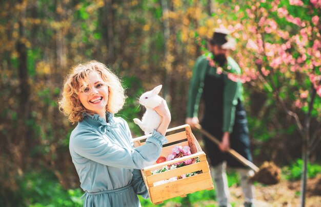 Lente vrouw en konijn meisje plezier op paaseieren zoeken