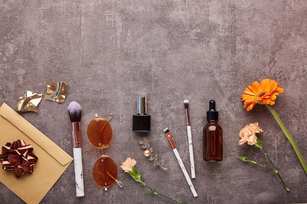 Lente vrouwelijke set met make-up kwasten accessoires etherische olie bloemen met kopieerruimte Esthetisch vrouwelijk achtergrondconcept van cadeaubon