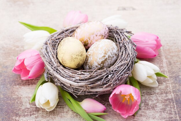 Lente wenskaart. Paaseieren in het nest. Lente bloemen tulpen.