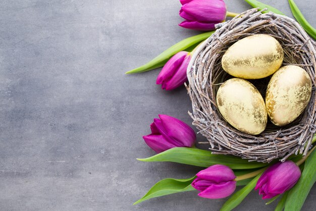 Lente wenskaart. Paaseieren in het nest. Lente bloemen tulpen.