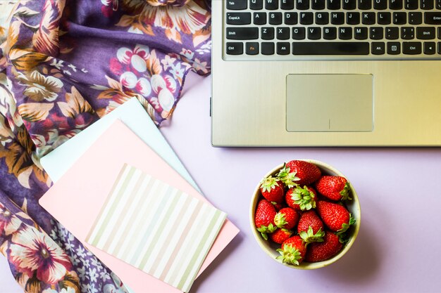 Lente werkplek met laptop, laptop en een schaal met aardbeien