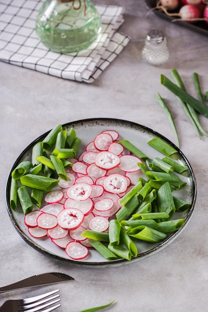 Lente zelfgemaakte radijs en bieslook salade op een bord op de tafel verticale weergave