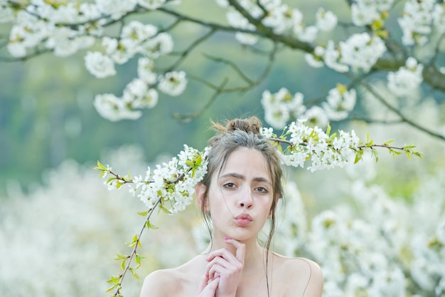 Lentebloem in kersentuin met mooi jong meisje of vrouw op natuurlijke achtergrond