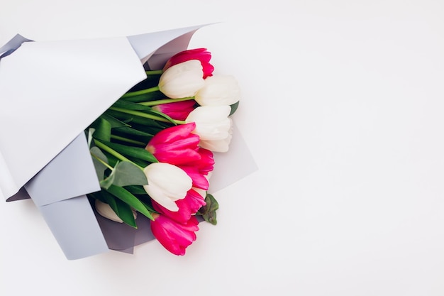 Lentebloemen geïsoleerd op witte achtergrond Womens day Boeket van witte en roze tulpen met lint Present cadeau voor Moederdag Space