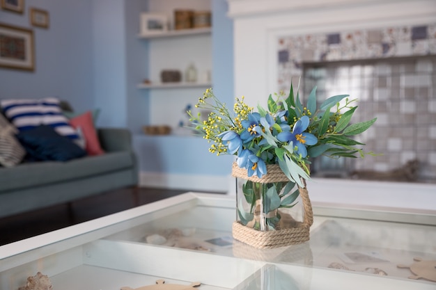 Lentebloemen in glazen vaas op kleine tafel