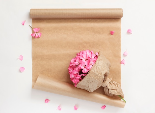 Lenteboeket van roze bloemen in kraftpapier met inpakpapier