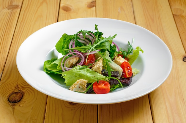 Photo lenten salad with onion, beetroot, tomato, feta and sesame