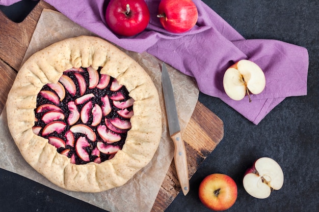 Lenten sweet galette with apples and elder berries on wooden board Flat lay top view