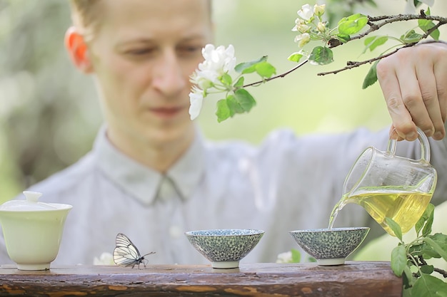 lentethee, Chinese groene verse thee, vlinder op bloemen, geluk en Aziatische meditatie in de lente