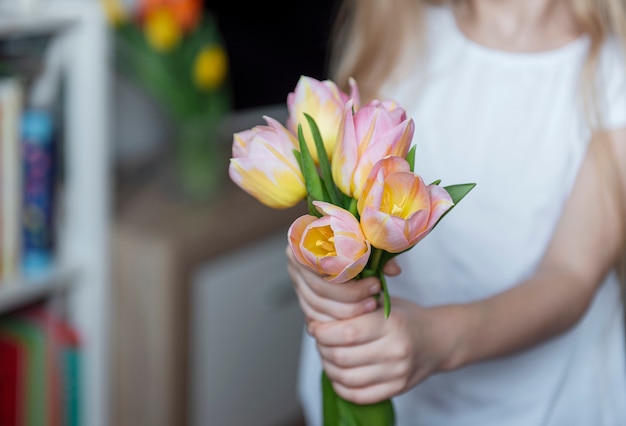 Lentetulpen in de handen van een klein meisje