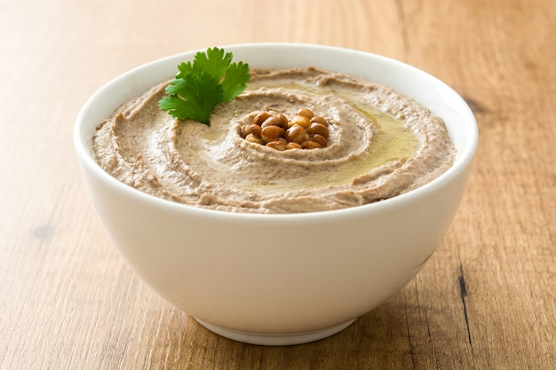 Lentil hummus in bowl on wood