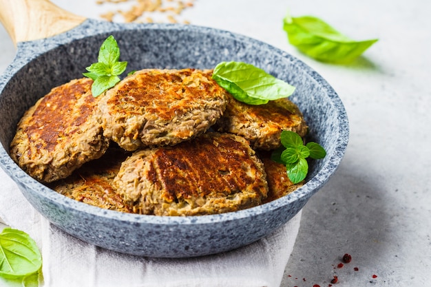 Lentil patties in gray frying pan. Healthy vegan food concept.