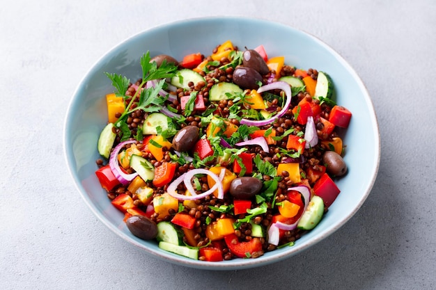 Lentil salad with vegetables in bowl Grey background Close up