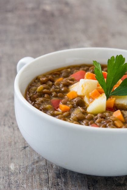 Lentil soup in a bowl on wooden table