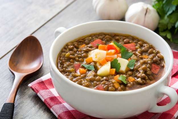 Lentil soup in a bowl on wooden table