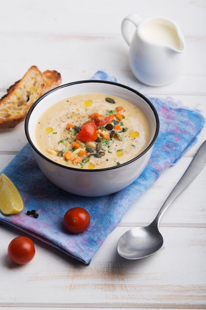 Lentil soup puree with tomatoes, cucumber and nuts in a bowl