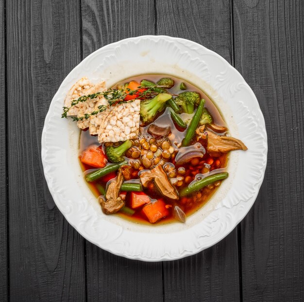 Foto zuppa di lenticchie con funghi porcini al buio