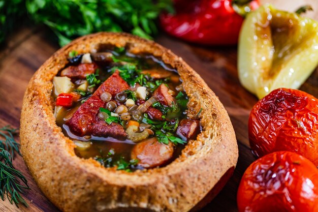 Фото Чечевичный суп с копчеными свиными ребрышками в тарелке хлеба