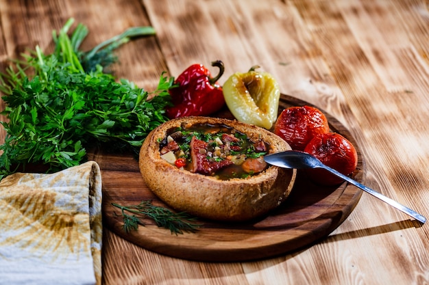 Lentil soup with smoked pork ribs in a plate of bread