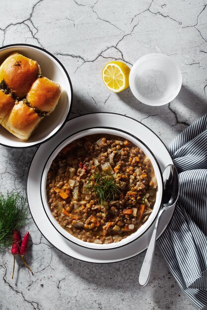 Lentil soup with vegetables and bread rolls on a concrete background healthy vegan meal