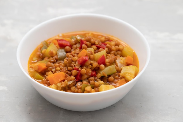 Lentil with pepper courgette and onion on white dish on ceramic