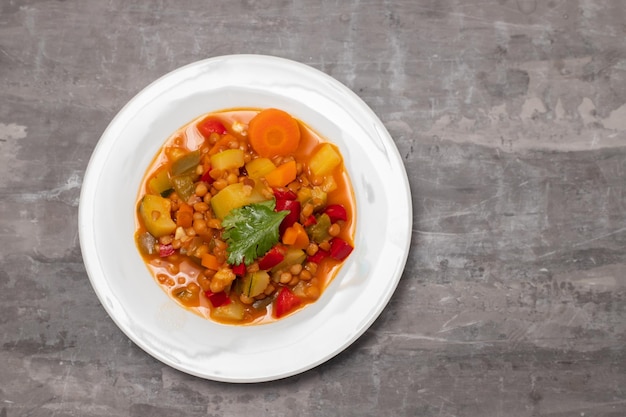 Lentil with pepper courgette and onion on white dish