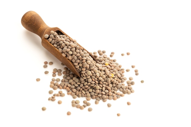 Lentil on wooden scoop isolated on white background. lens Variabilis