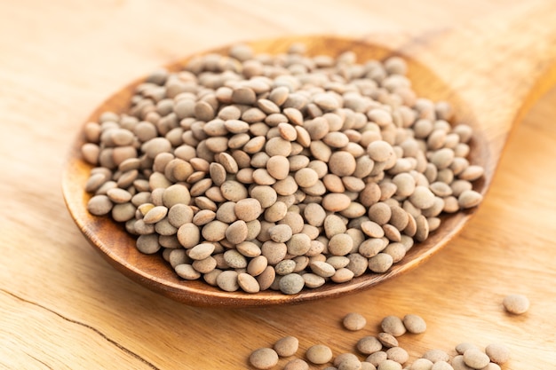 Lentil on wooden spoon on table. lens Variabilis