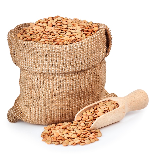 lentils in bag with wooden scoop isolated on white background